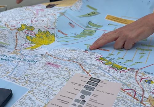 Guide explaining a detailed map of the D-Day landing beaches in Normandy.